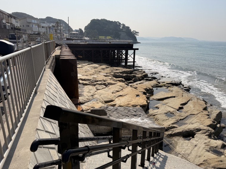 砂が無くなって露出した岩盤と津波対策用の擁壁工事